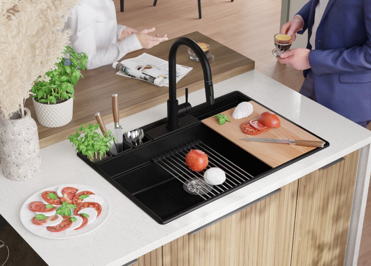 Küchenspüle mit Abtropfgestell, Schneidebrett und Armatur auf einer Küchentheke mit Zutaten für Caprese.