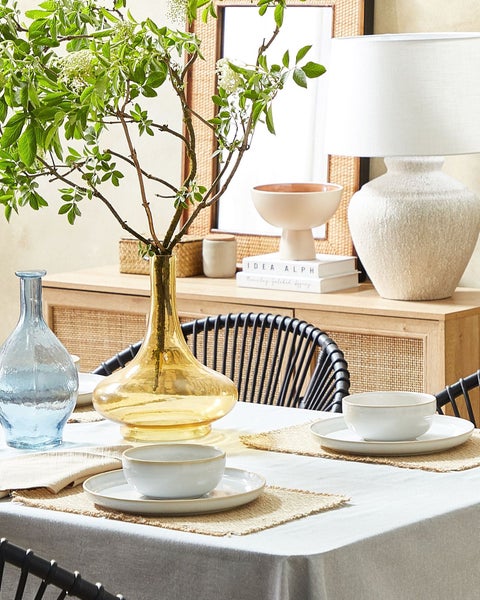 Esstisch mit Geschirr, Vasen und Dekoration auf einem Sideboard