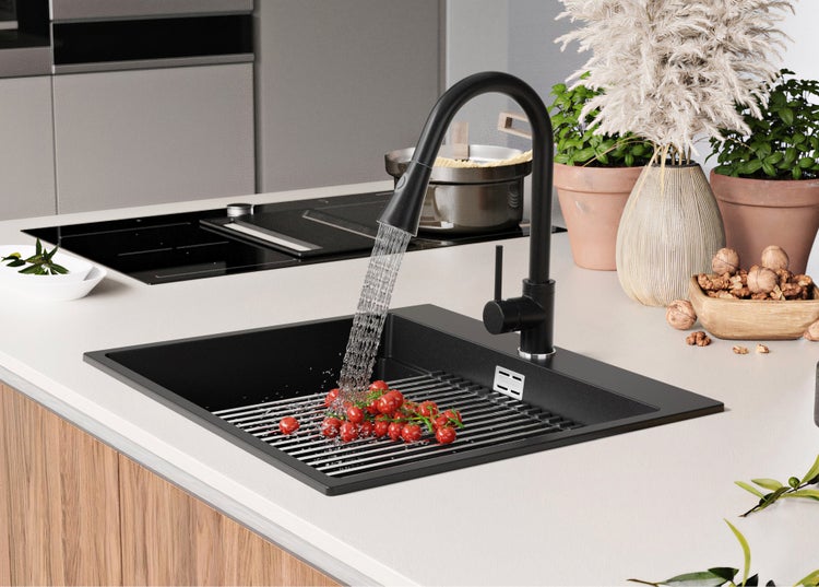 Schwarze Küchenspüle mit Armatur und Tomaten