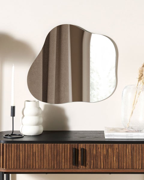 Dekorative Szene mit Spiegel in ungewöhnlicher Form, Konsole, Kerzenständer und Vase