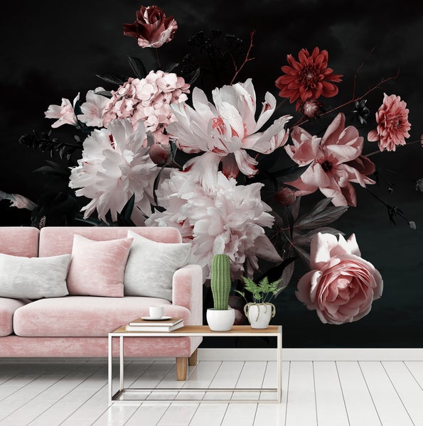Fototapete mit großflächigem Blumenmotiv hinter einem rosa Sofa in einem modernen Wohnzimmer mit hellem Holzboden.