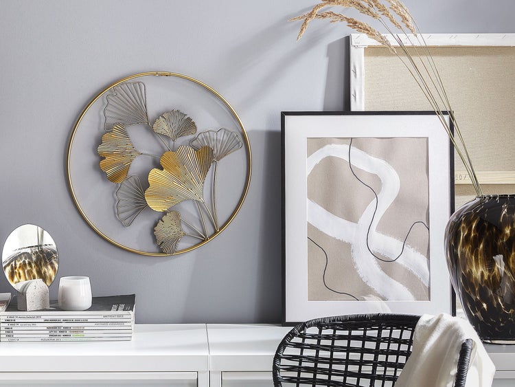 Dekoratives Interieur mit Wanddekoration, gerahmtem Bild und Blumenvase