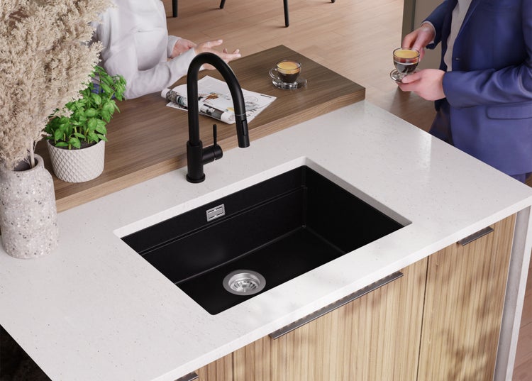 Schwarzes Spülbecken mit Armatur in einer modernen Küche.
