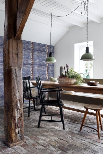 Heller Raum mit Esstisch, Stühlen und Pendelleuchten im Industrie-Stil.
