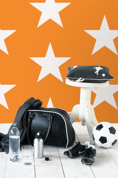 Szene mit Sporttasche, Fußball, Fußballschuhen, Wasserflasche und Hocker