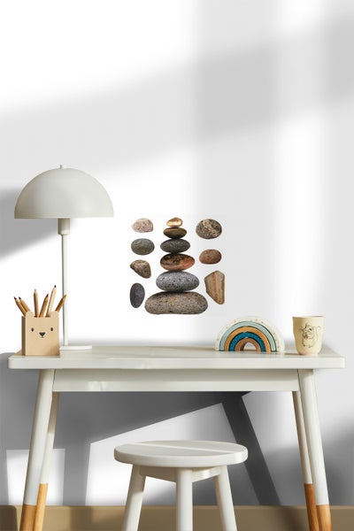 Dekoratives Poster mit Steinen auf einem Schreibtisch mit Lampe, Stifthalter und Dekoration