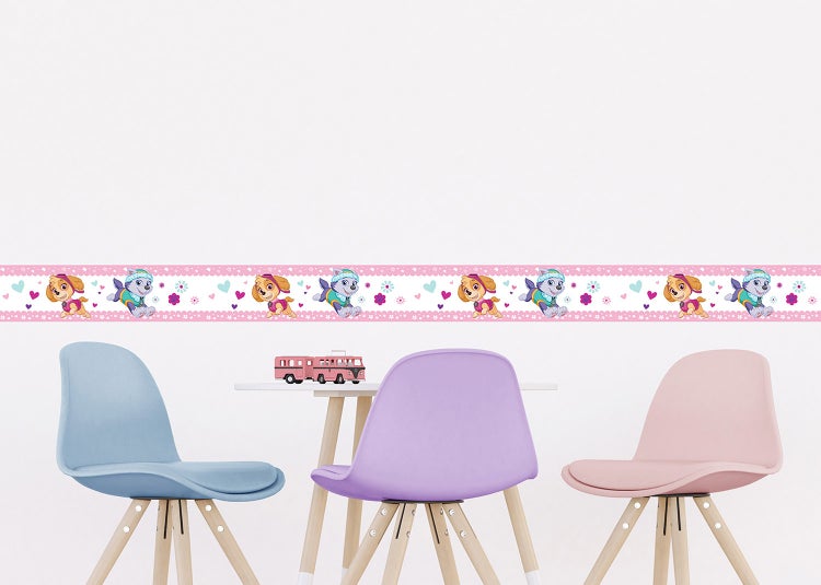 Selbstklebende Tapetenbordüre mit Paw Patrol Motiven Skye und Everest, Blumen und Herzen in einem Kinderzimmer mit Stühlen und Tisch.