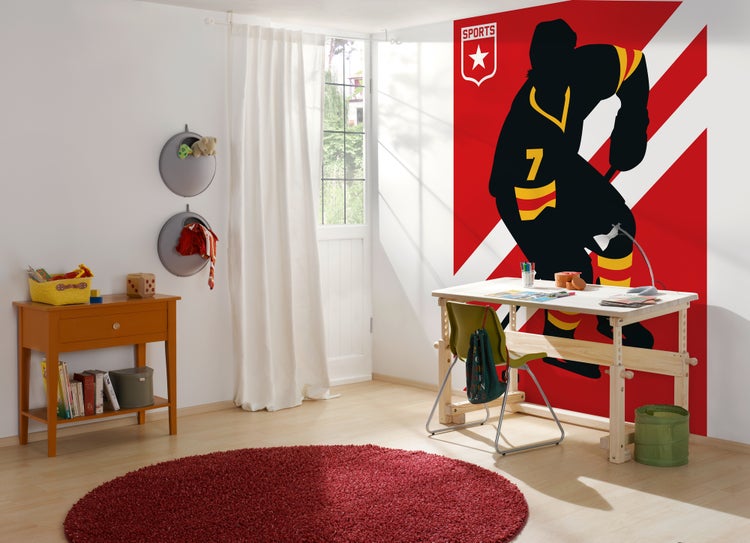 Helles, organisiertes Kinderzimmer mit Fototapete eines Eishockeyspielers, Holzschreibtisch, Stuhl und rundem Teppich.