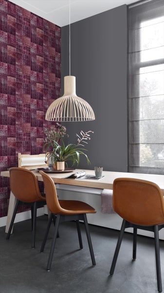 Esszimmer mit gemusterter Tapete, Holztisch, Stühlen und Pendelleuchte