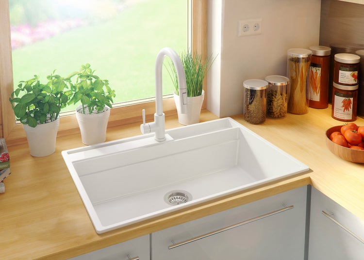 Küchenszene mit Spüle, Armatur und Dekorationsgegenständen auf einer Arbeitsplatte