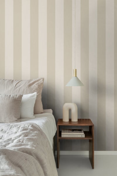 Schlafzimmer-Szene mit gestreifter Tapete, Nachttisch, Lampe und Bett