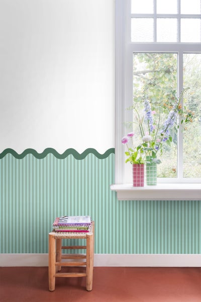 Dekoriertes Zimmer mit gestreifter Tapete, Blumen und einem kleinen Hocker