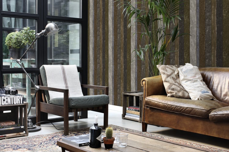 Wohnzimmer mit Sessel, Sofa, Stehlampe und Holzwandpaneelen für ein gemütliches Ambiente.