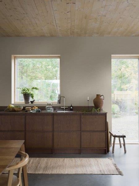 Helle Küche mit Holzdecke, Fenstern und Küchenzeile mit Spüle und Dekorationen