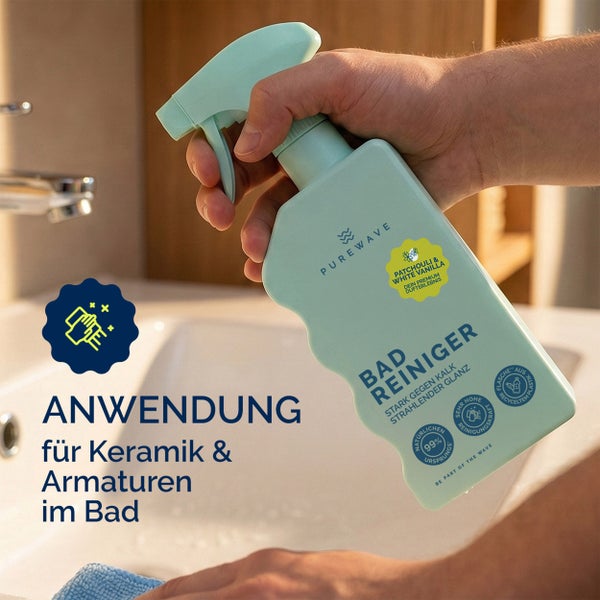 Eine Hand hält eine Sprühflasche Badreiniger der Marke Purewave vor einem Waschbecken. Auf der Flasche steht Anwendung für Keramik und Armaturen im Bad.
