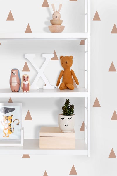 Regal mit Dekorationsgegenständen wie Holzspielzeug, Matroschka Puppen, Stofftier und einer Zimmerpflanze