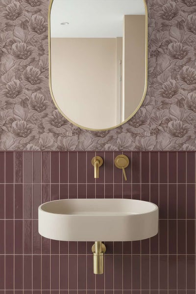 Kind sitzt auf einer Holzbank vor einer Wand mit Vliestapete mit Blumenmuster.
