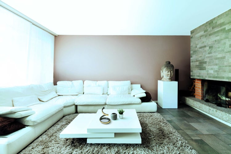 Wohnzimmer mit weißer Couch, Couchtisch, Dekoration und Kamin