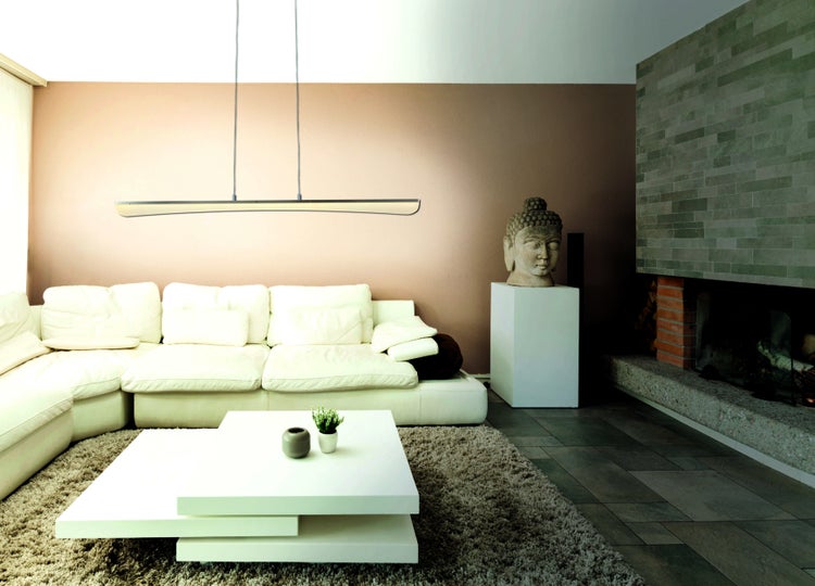 Wohnzimmer mit Sofa, Tisch, Pendelleuchte und Dekoration für ein gemütliches Ambiente