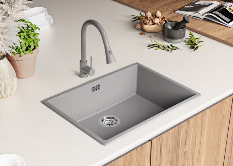 Spüle aus Stein mit Wasserhahn in einer Küchenanordnung.