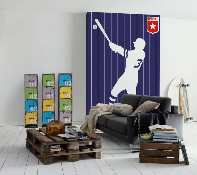 Helles Wohnzimmer im Industrial-Stil mit Baseball-Fototapete, schwarzem Sofa, Couchtisch aus Paletten, bunten Schränken und Sportausrüstung.