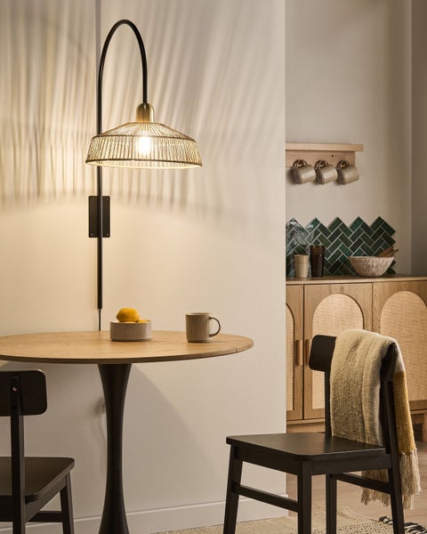 Einrichtungsszene mit Wandleuchte, Esstisch und Stühlen in einem stilvollen Interieur.