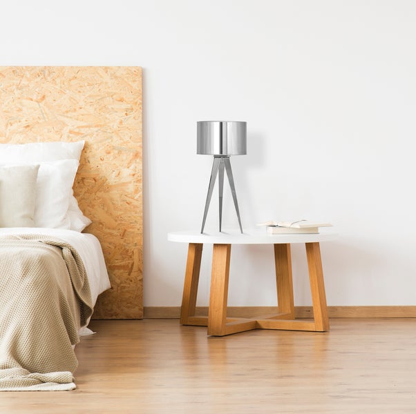 Schlafzimmer mit Bett, Nachttisch und Stativlampe