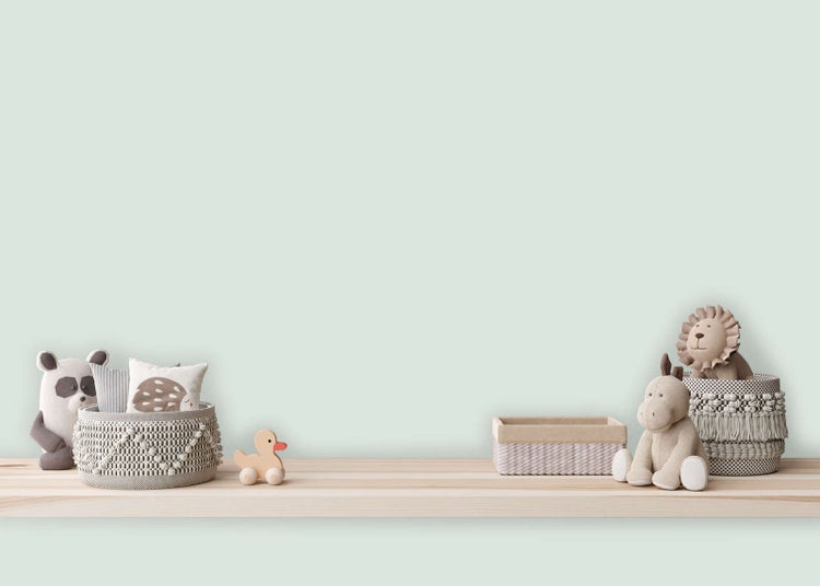 Wandfarbe in hellem Mintgrün in einem hellen, organisierten Kinderzimmer mit Holzregal, Stofftieren und geflochtenen Körben.