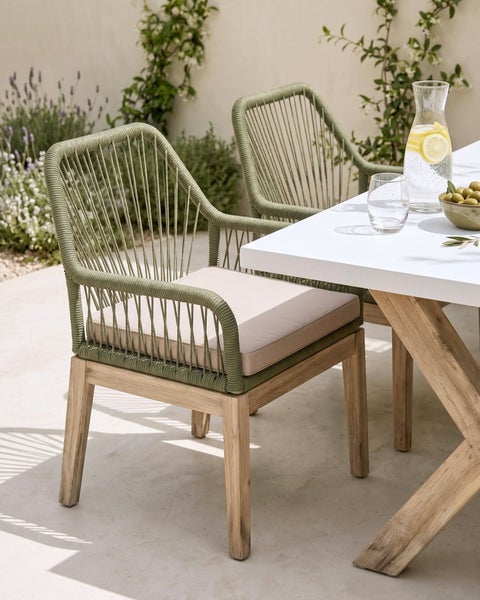 Moderner Gartenstuhl mit Holzgestell, olivgrüner Seilbespannung und Sitzkissen an einem Esstisch auf einer Terrasse.