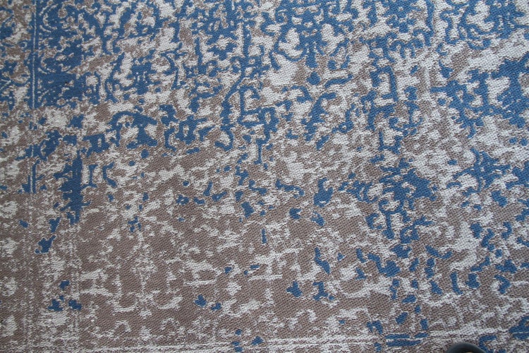Teppich mit blau-grauem Vintage-Muster im Used-Look und abstraktem Design.