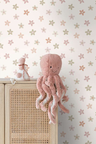 Kindertapete mit Blumenmuster vor einem Schrank mit Rattanfront und einem Oktopus Plüschtier als Dekoration im Kinderzimmer.