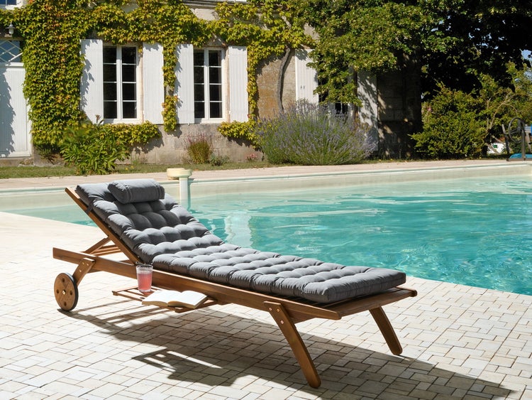Holzliege mit grauer Auflage am Pool