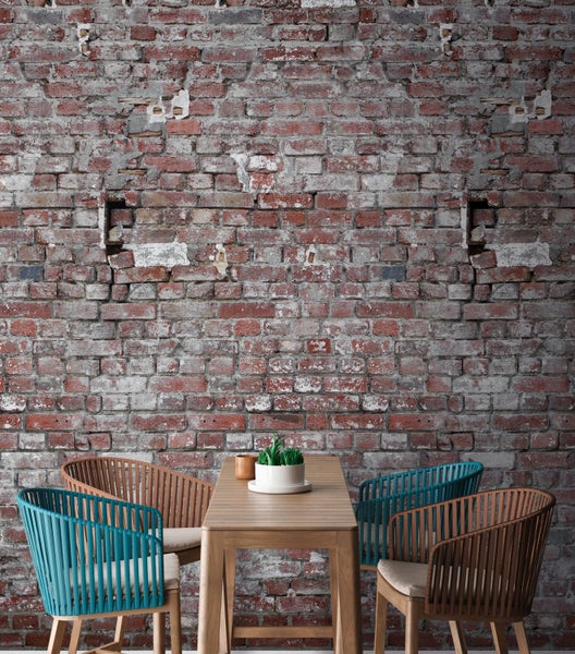 Szene mit Holztisch und Stühlen vor einer Ziegelwand