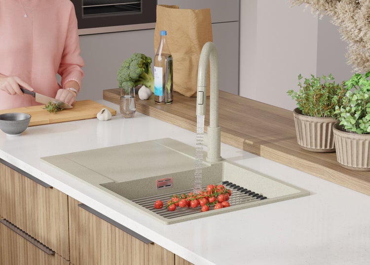 Küchenszene mit Spüle, Armatur, Gemüse und Kräutern auf der Arbeitsfläche