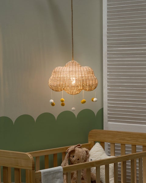 Wolkenlampe aus Rattan mit Stoffbällen über einem Kinderbett