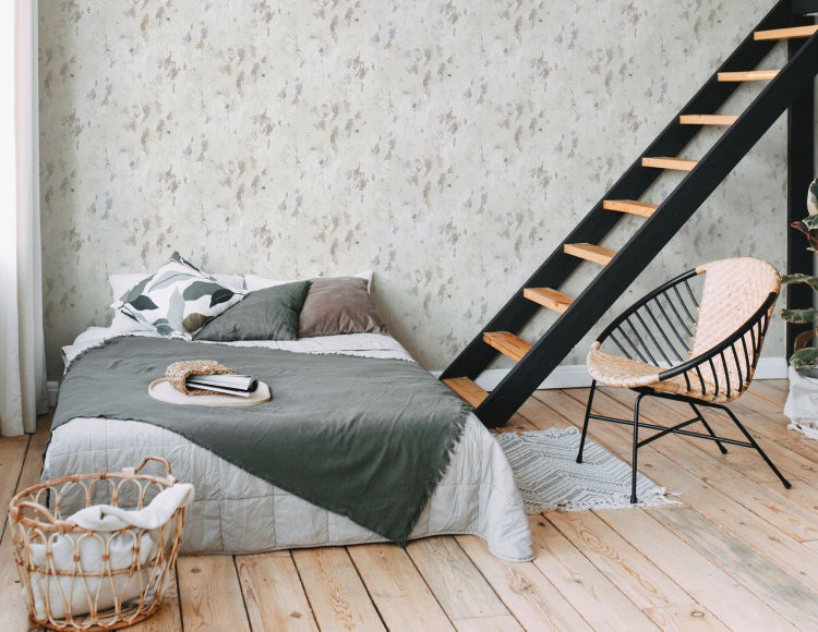 Schlafzimmer mit Holzbett, gemusterter Tapete, Beistelltisch und Zimmerpflanze im Korb