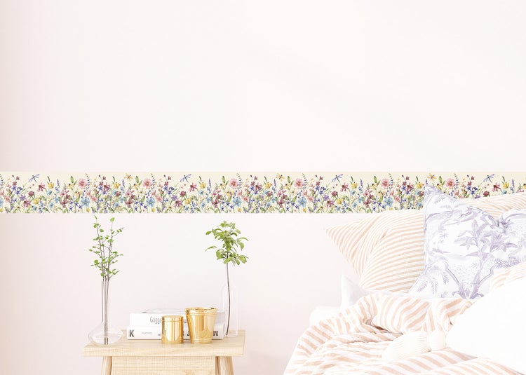 Selbstklebende Tapetenbordüre mit Blumenwiesen- und Libellenmotiv in einem hellen Schlafzimmer.