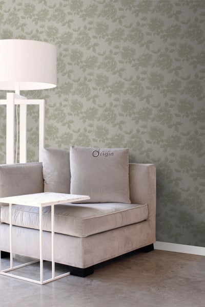 Wohnzimmer mit grauer Blumentapete, Lampe, Couch und Beistelltisch