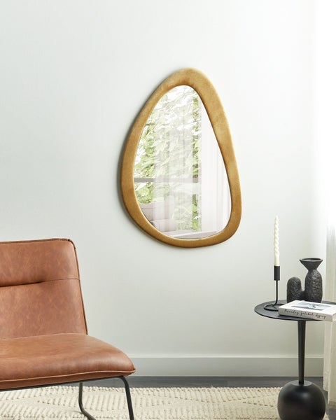 Wohnzimmer mit Sessel, Beistelltisch und dekorativem Wandspiegel