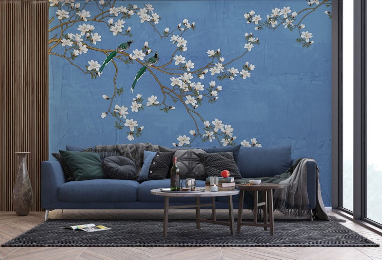 Wohnzimmer mit Sofa, Couchtisch und Wandtapete mit floralem Muster und Vögeln