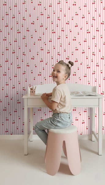 Kinderzimmer mit Schreibtisch, Hocker und Tapete mit Kirschmuster