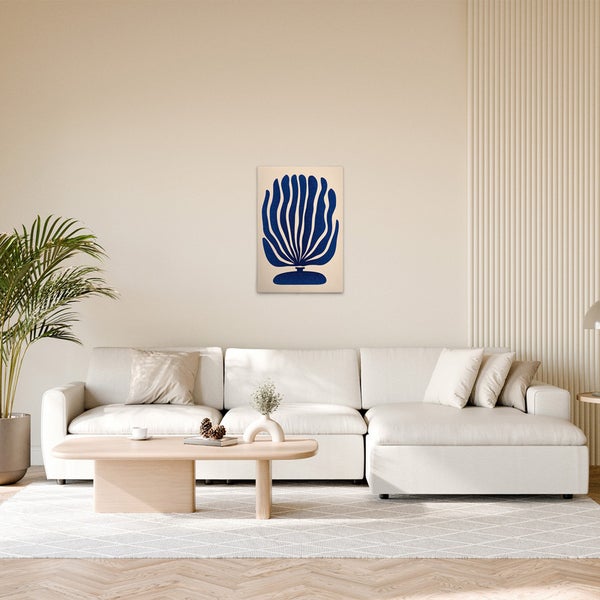 Wohnzimmer mit Sofa, Tisch und Wandbild mit Pflanzenmotiv