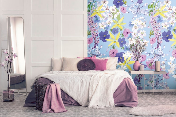 Helles Schlafzimmer mit Bett, Blumenmustertapete und dekorativen Accessoires für eine freundliche Atmosphäre.