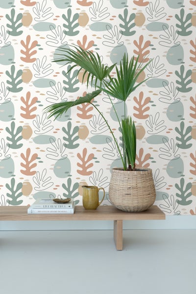 Dekorative Tapete mit Pflanzenmotiven hinter Tisch mit Topfpflanze