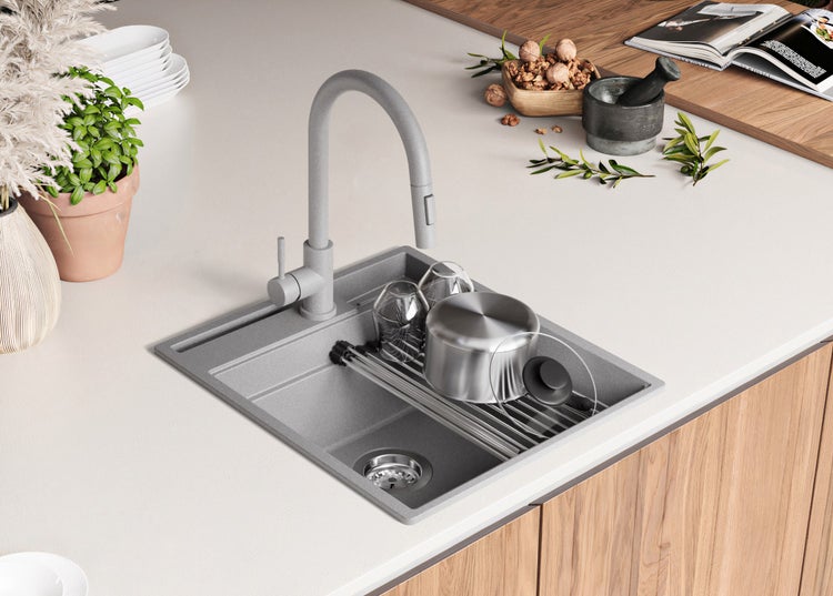 Spüle mit Abtropffläche, Wasserhahn und Geschirr auf einer Küchentheke