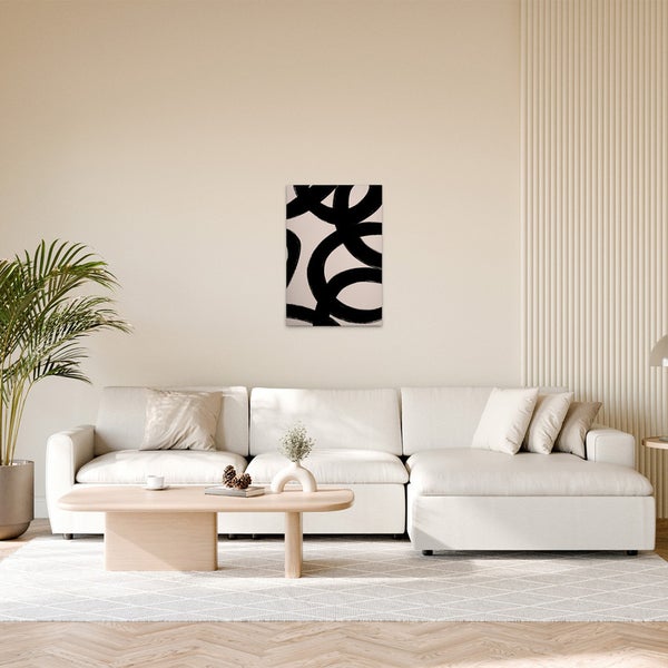 Wohnzimmer mit Sofa, Tisch und einem Wandbild mit abstrakten Kreisen.