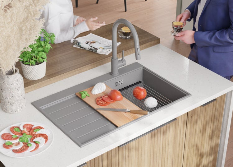 Spüle aus Granit mit Schneidebrett, Tomaten, Mozzarella und Wasserhahn in einer hellen Küche