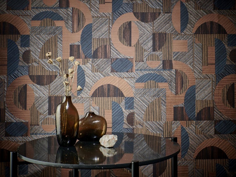 Tapete mit Blumenmuster auf einer Wand, kombiniert mit einer dekorativen Tischarrangierung mit Büchern und Blumen in Vasen