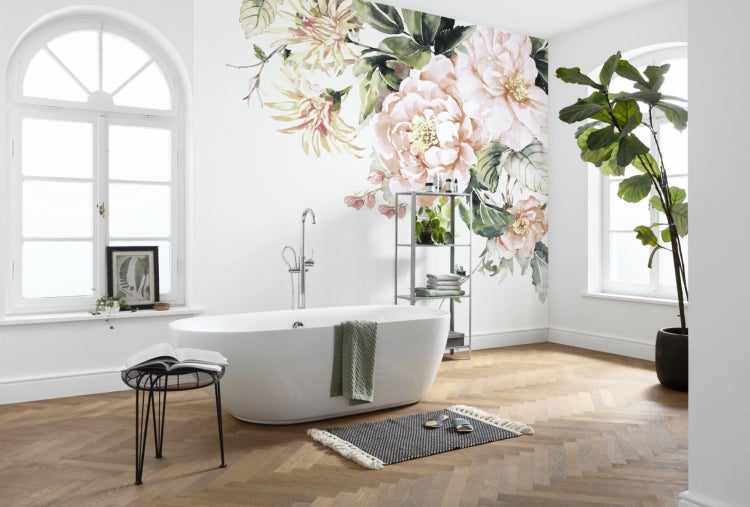 Helles Badezimmer mit freistehender Badewanne, Regal, Zimmerpflanze und floralem Wandtattoo.