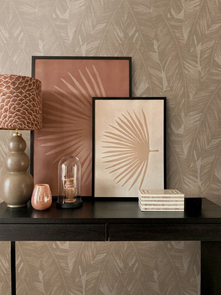 Dekoratives Interieur mit Tischlampe, Bildern, Kerzenständer und Schmuckschatulle auf einem schwarzen Tisch.